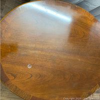 Top view of round wooden table surface showing wear and wood grain