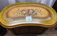Photo of the kidney-shaped top of the Victorian style table showing detailed floral hand-painted design and gold accents.