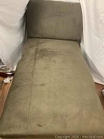 Full view of green chaise lounge showing the seat and backrest upholstery and its textured surface.