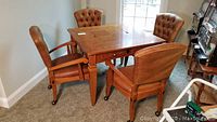 Full view of square game table and four matching chairs in room