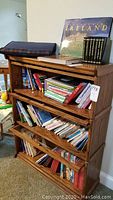Front view of the wooden barrister bookcase filled with books and items on top
