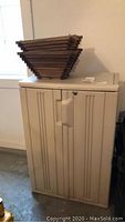 Beige plastic utility cabinet with vertical lines and large handles.