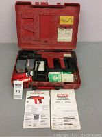 Hilti DX 450 stud fastener tool, accessories and manuals in red carrying case