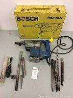 Full lot showing Bosch hammer drill, various attachments, and yellow carrying case