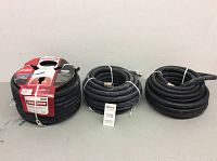 Set of three black rubber garden hoses, one with packaging, two used without packaging.