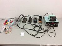 Overview of Weller repair stations, iron holders, tools and solder spools on table