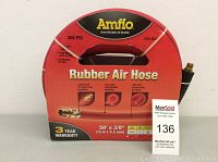 Front view of the Amflo Rubber Air Hose packaging showing brand, product name, size, and PSI rating with hose handle and brass fitting visible.