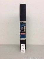 Rolled black rubber floor mat sealed in original packaging with label showing brand and product details.