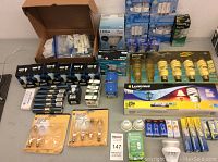 Full overview of assorted boxed and loose light bulbs in various brands and types including LED, halogen, CFL, incandescent