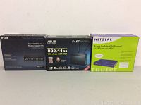 Three boxed networking devices: D-Link Gigabit VPN Router, ASUS Wireless AC1900 Router, and NETGEAR ProSafe VPN Firewall.