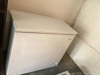 Side angle view of the white Brada deep freezer showing overall shape and condition.