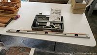 Photo of the knee kicker, level and yardstick laid out on table