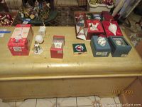 Wide view of assortment of boxed and unpacked vintage holiday ornaments on wooden chest