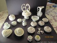 Overview of 17 white decorative ceramic and porcelain items including boxes, candlesticks, floral dishes, vase, and number 60 figurine