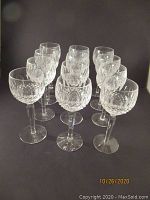 Front view of twelve crystal wine glasses arranged in rows.