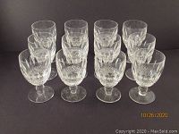 Twelve Waterford crystal goblets arranged in rows showing their cut crystal detail and overall shape.