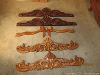 Six distinct carved wooden wall decor pieces laid out on carpet. Longest piece 39x8 inches. Pieces include ornate floral and shell carving details.