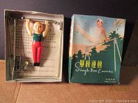 Vintage toy figure in box labeled 'Single Bar Exercise' with Chinese text, showing toy in upper left corner of box