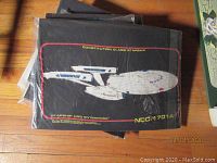 Black T-shirt with white illustration of Constitution-class USS Enterprise NCC-1701A and red border