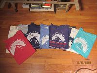 Seven large vintage T-shirts folded on wooden floor showing Paramount and Star Trek III print designs.