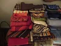 Photo showing folded scarves with various colors and patterns including polka dots, stripes, and animal prints.