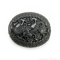 Front view of oval carved green jade medallion with dragon motif