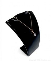 Front view of pearl pendant on 925 silver snake chain necklace displayed on black stand.