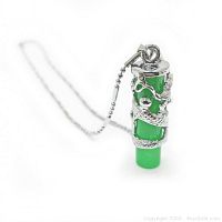 Close-up of green jade cylindrical pendant wrapped in detailed silver dragon design hanging on silver chain.