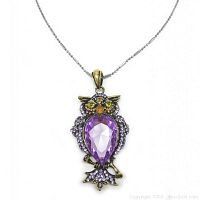 Front view of owl-shaped pendant necklace with purple rhinestones and yellow eyes on silver-tone chain.