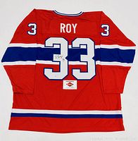 Back view of red jersey showing stripes, ROY nameplate, number 33 on back and sleeves, PAAS COA card.