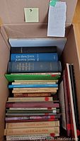 Box filled with nonfiction books mainly about Nova Scotia history, some green and blue hardcover books including The Nova Scotia Historical Society volume 25.
