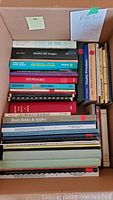 Top view of box containing nonfiction books with tags showing Nova Scotia related titles including 'Rawdon and Douglas' and 'Notable Pictonians'