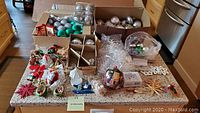 Wide view of all Christmas ornaments and the metal bird cage on countertop.