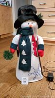 Full front view of fiber optic snowman decoration showing hat, scarf, mittens, broom, and embroidered snowflake on body.