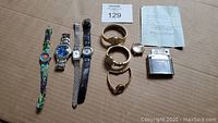 Full lot overview showing nine items: eight watches (various quartz movements and styles) and one metal lighter.