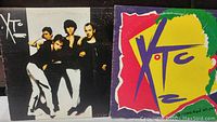 Two XTC vinyl albums showing the front cover art, including the band photo and colorful abstract face.
