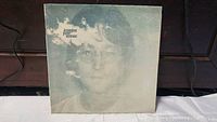 Front cover of John Lennon Imagine vinyl album showing faded image of John Lennon with text