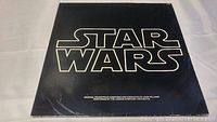 Front cover of the Star Wars soundtrack double vinyl album with the Star Wars logo on black background.
