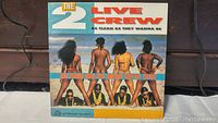 Front cover of The 2 Live Crew album showing the beach scene artwork with band members and women.