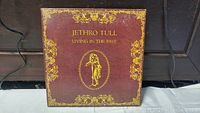 Front cover of Jethro Tull Living In The Past double album with burgundy and gold design.