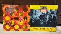 Front covers of two Talking Heads vinyl records, one displaying colorful circular patterns and the other featuring a black and white band photo with yellow title area.