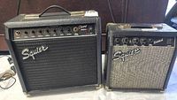 Front view of two Squire guitar amplifiers: Champ 15GR on left and Sidekick on right showing front panels, grille cloths, controls and logos.