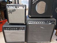 Front view of four guitar amplifiers stacked, showing branding and control panels.
