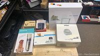 Overview photo of all pet-related items in their original packaging, including pet door, cat bowl, training collar, clippers, and bark control devices.