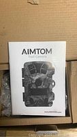 Closed box of AIMTOM trail camera with branding