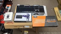 Overview photo of all boxed and unboxed electronic items on table including the keyboards, XP-Pen tablet, wireless mouse, and packaging for Avazz keyboard.
