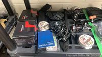 Photo showing fishing reels, boxes, instructions and fishing lines on a shelf.