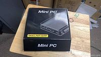 Closed original box labeled 'Mini PC Small, Fast, Quiet' showing compact computer unit illustration.