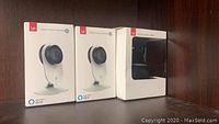 Three boxed YI cameras displayed on shelf: two 1080p Home Cameras and one Dome Camera, all open box.