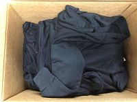 Box containing folded black fleece hoodies in youth sizes